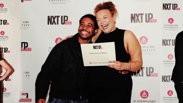 People are posing for photos at the NXT UP Fest, organized by Academy of Art University. Central individuals hold certificates labeled "Nxtup Festival Winner," with a backdrop displaying event logos.